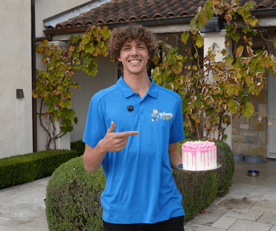 Asher from Winning Window Cleaning celebrating a team milestone while on-site at a coastal North Shore property.