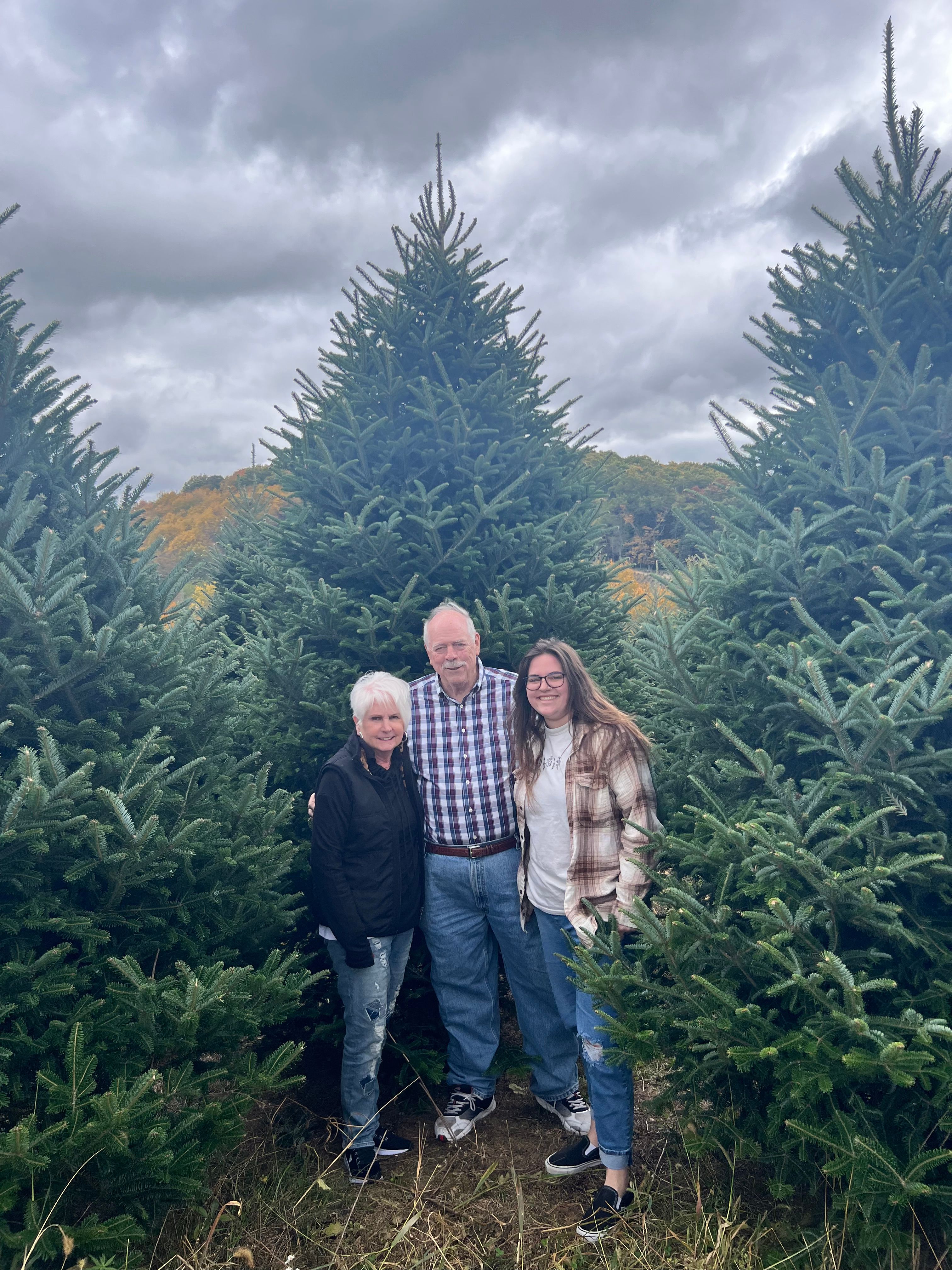 hodge family standing at christmas tree farm