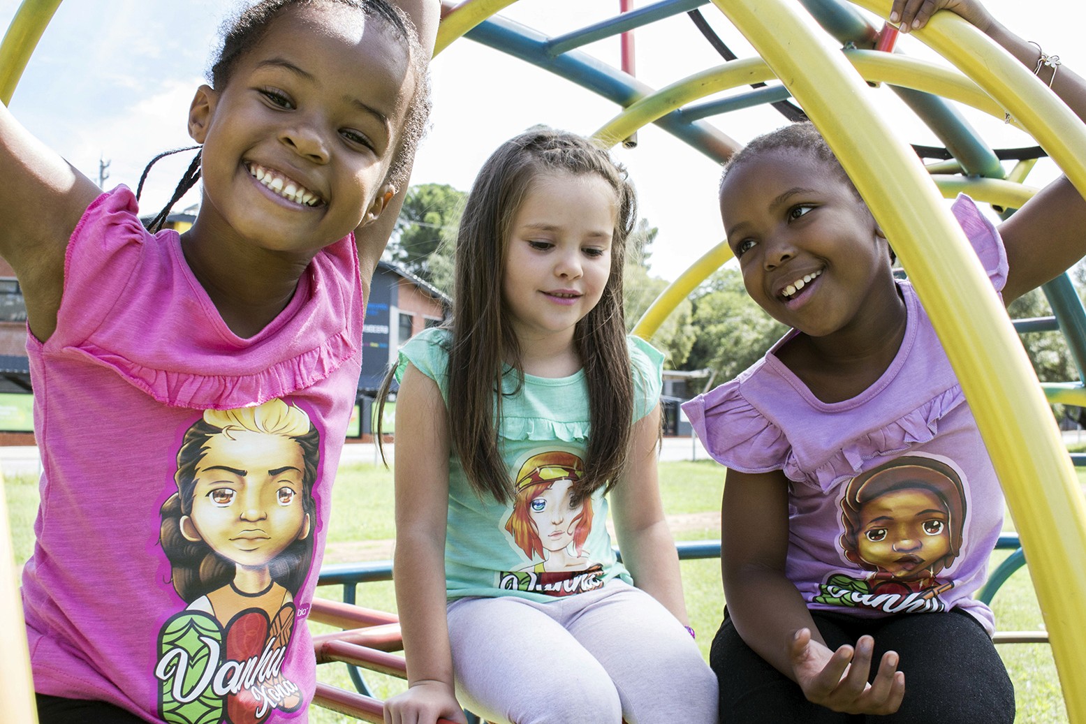 Thre girls on a jungle gym while wearing KN Studios merchandise