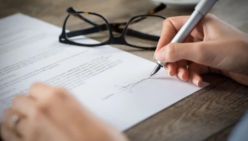 a pen writing on a piece of paper, illustrating the Residence Permit Renewal