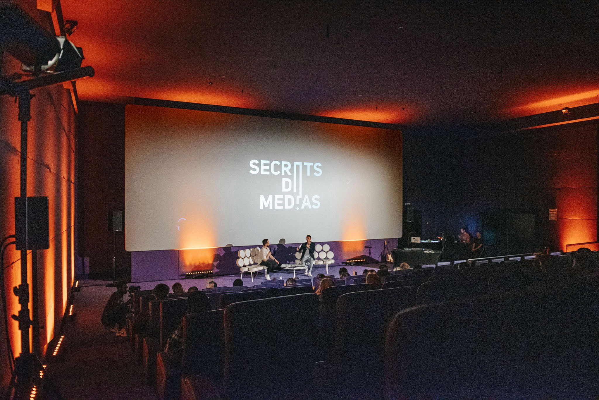 Modern home office setup with a monitor, ergonomic chair, keyboard, and indoor plants near a window with blinds.