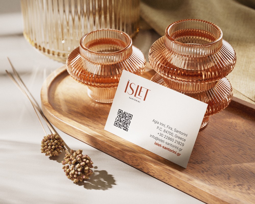 ISLET Santorini business card showcased in a natural setting, with materials that highlight the brand’s aesthetic