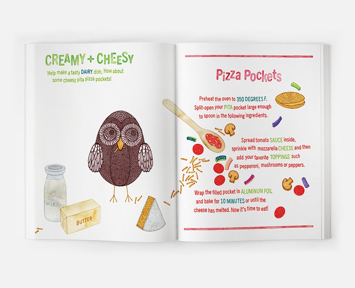 An open cookbook displays a recipe for "Creamy + Cheesy" pizza pockets. The left page features a cartoon owl illustration, milk bottle, butter, and shredded cheese. The right page shows a recipe with instructions: preheat the oven to 350°F, split open the PITA pocket, spoon the ingredients, and wrap the filled pocket in aluminum foil.