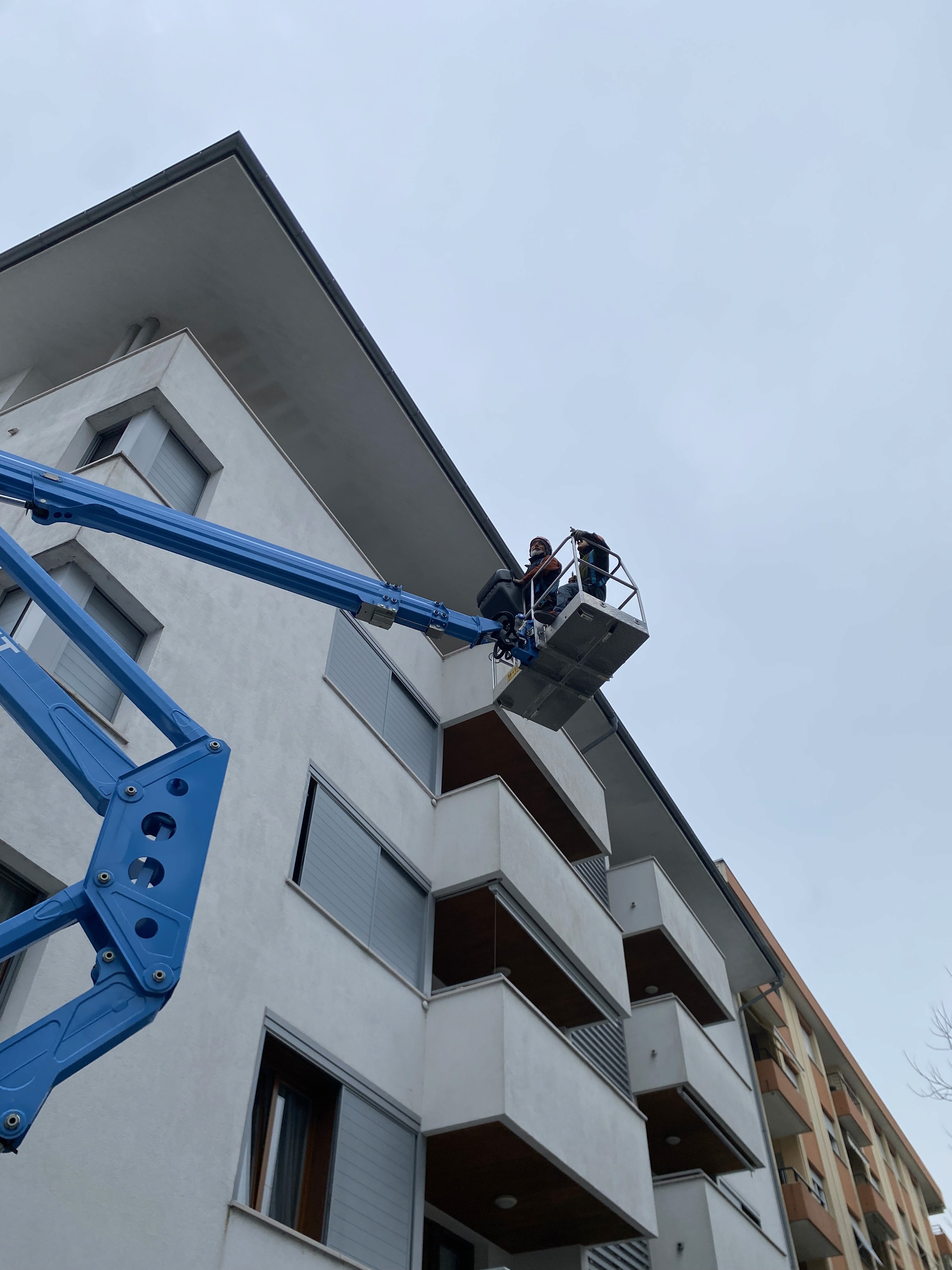 a man in a yellow shirt is working on a roof