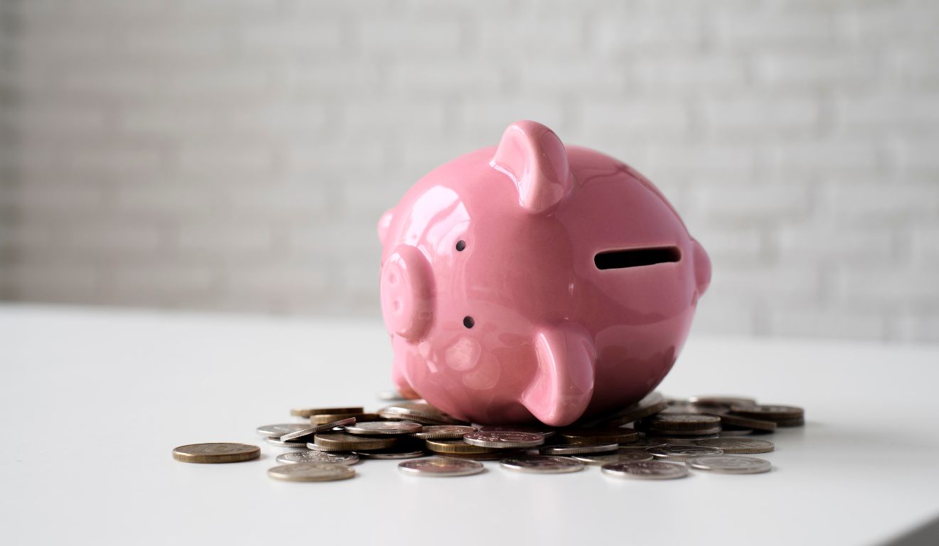 Imagem mostra cofrinho com moedas ao redor para economizar