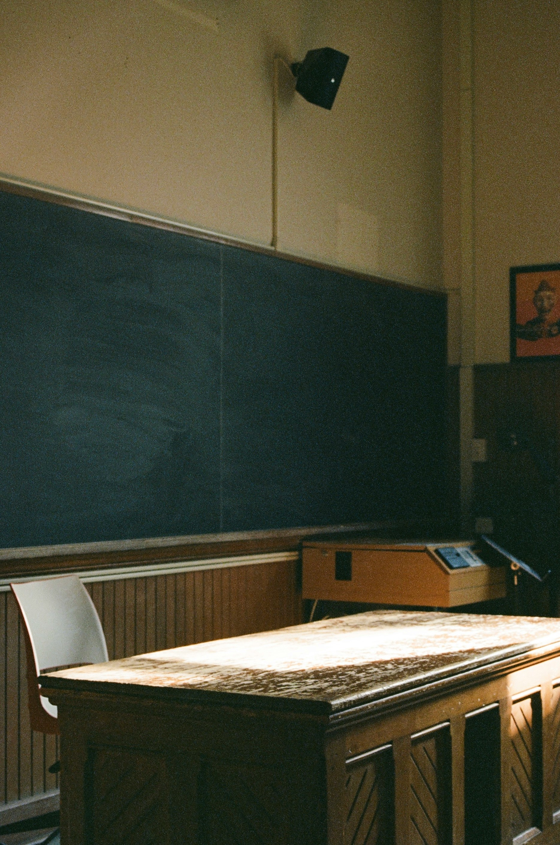 An empty classroom with a blackboard and desk