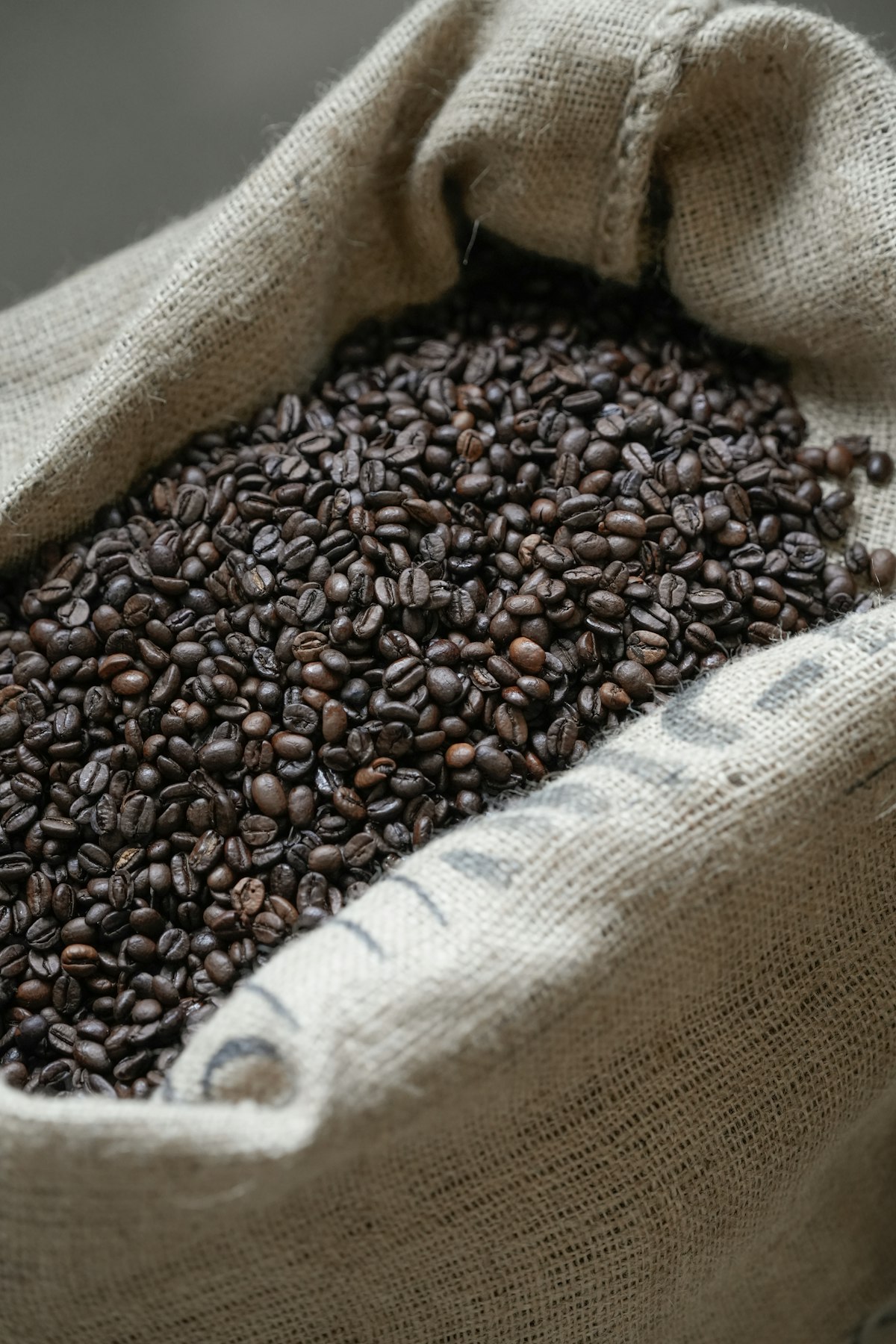 Saco de yute abierto lleno de granos de café tostado