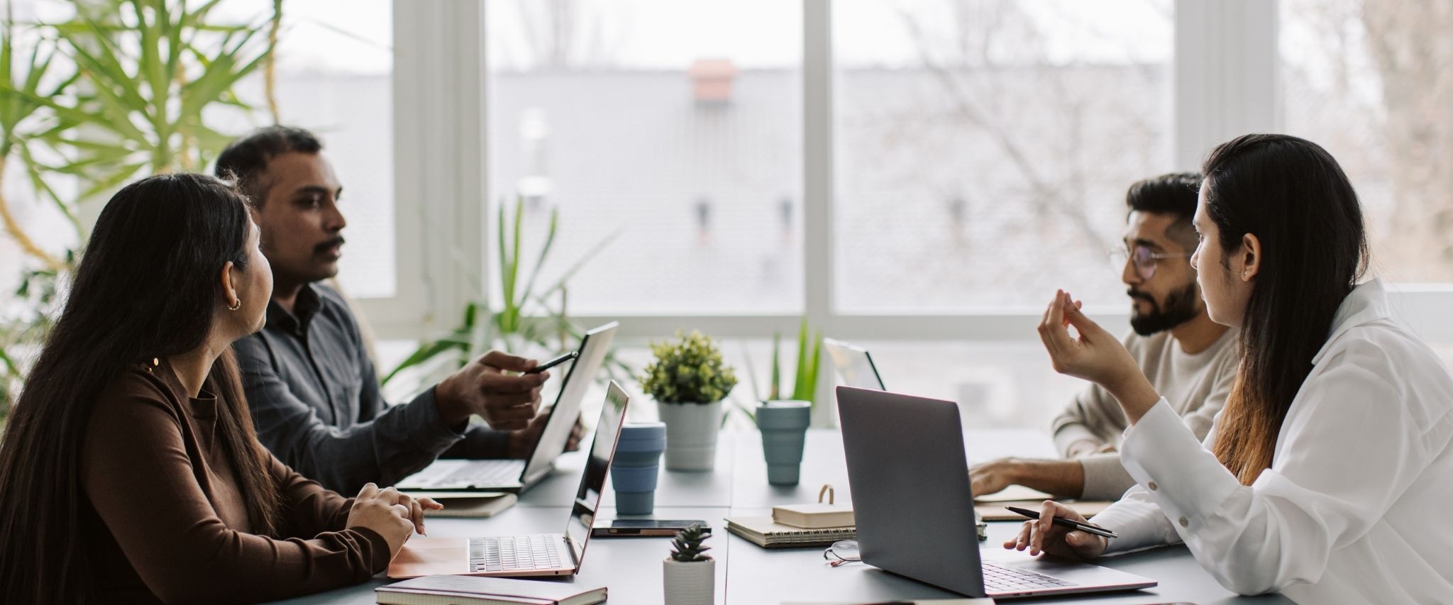 The team working together at a table with laptops, discussing business strategies or projects.