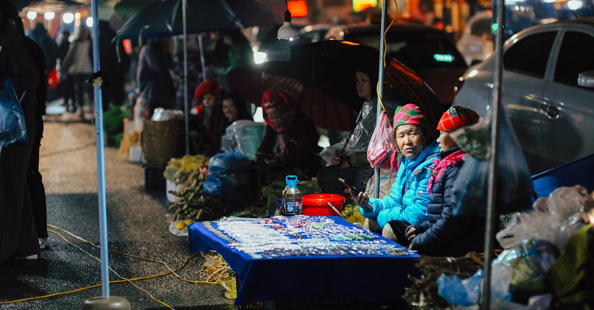 Local vendors at a lively night market showcasing colorful hats and goods.