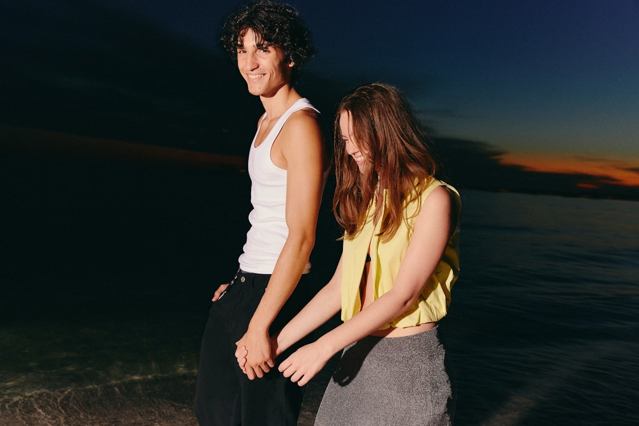 couple holding hands walking on beach