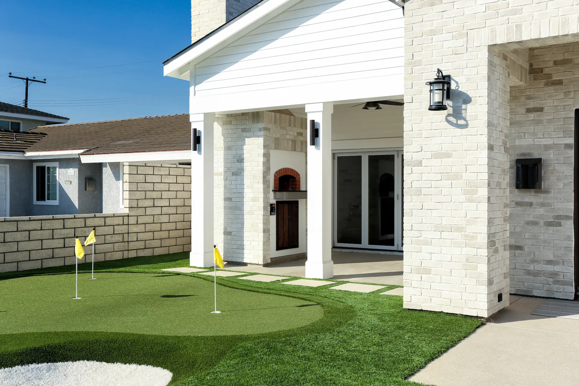 Close-up angled view of American Farmhouse home with font yard putting green. Photo by Chris Darnall.