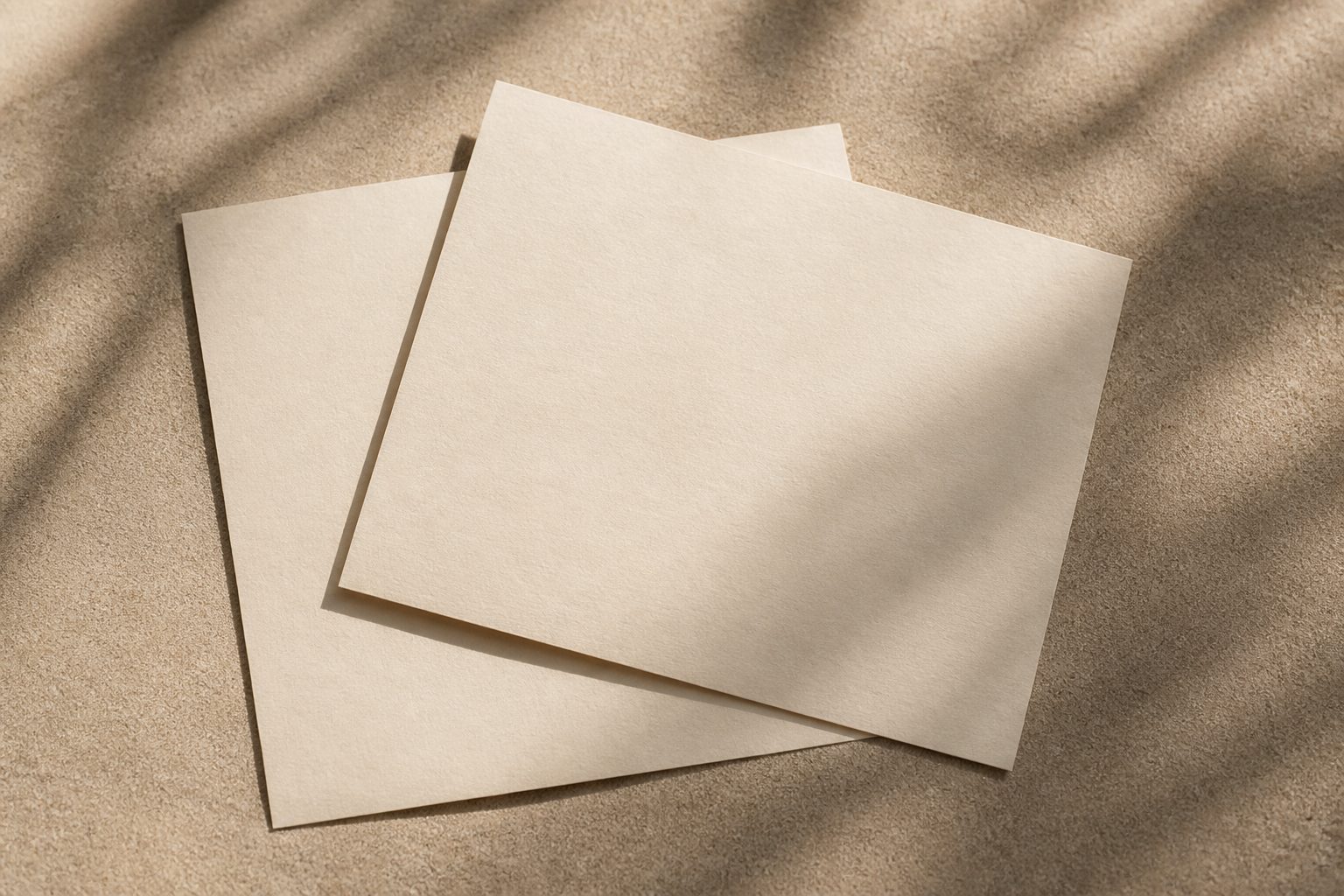 Two overlapping cream sheets, the top one rotated so both edges show
