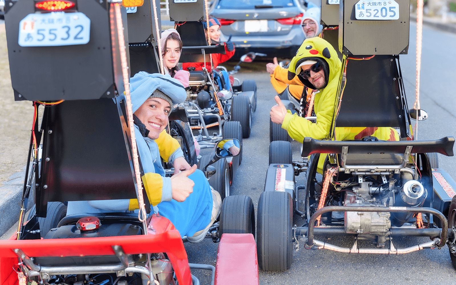 Những người bạn đang ngồi trong xe go-kart tại đường đua ở Dubai, tận hưởng trải nghiệm tham quan nhóm.