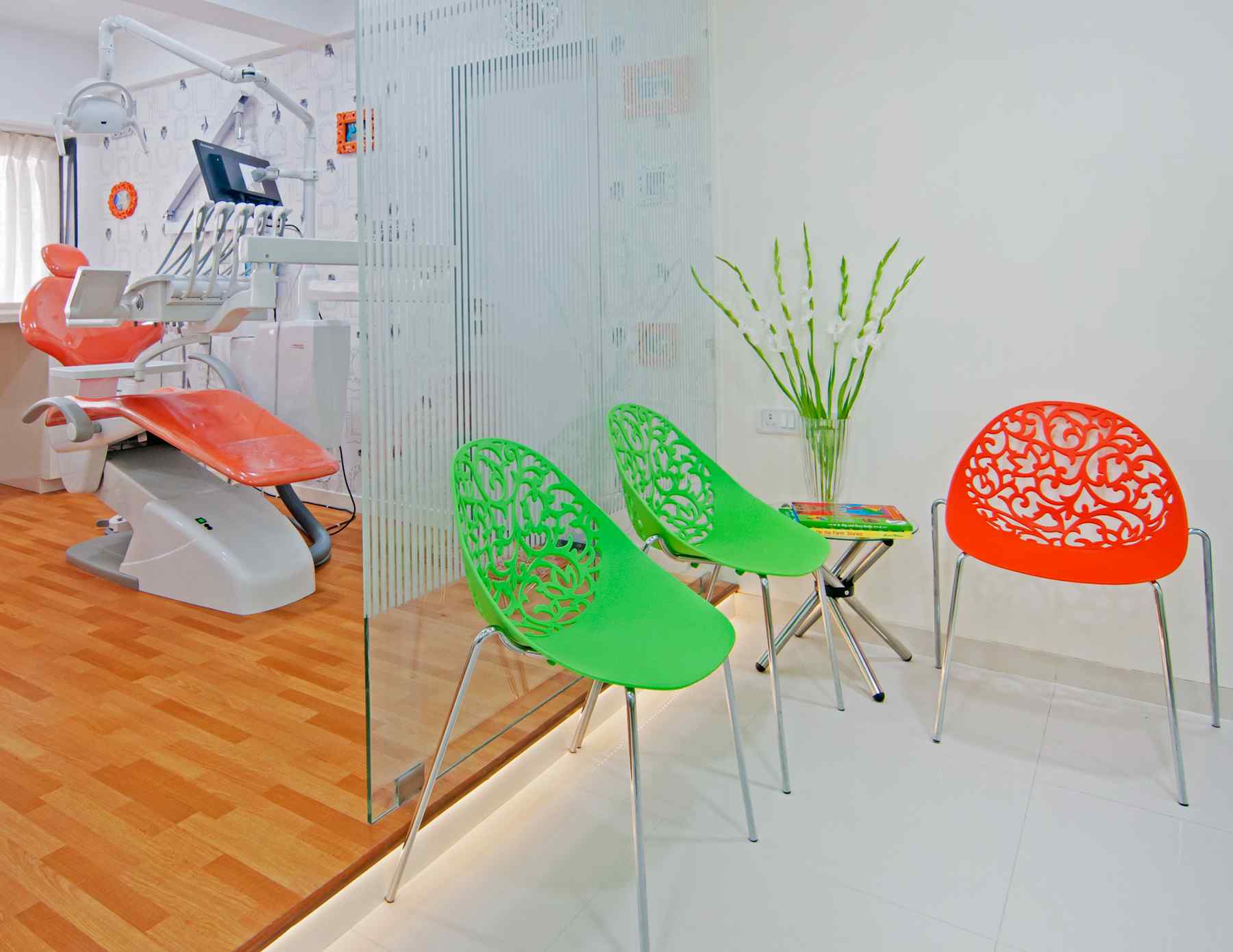 Nature-inspired preschool entrance with sculptural tree partitions and suspended green leaf ceiling panels.