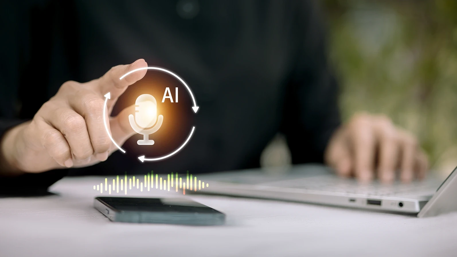 Hand activating an AI voice assistant on smartphone with glowing icon and waveform while working on laptop; speech-to-text, transcription, voice search and chatbot automation for productivity and acce