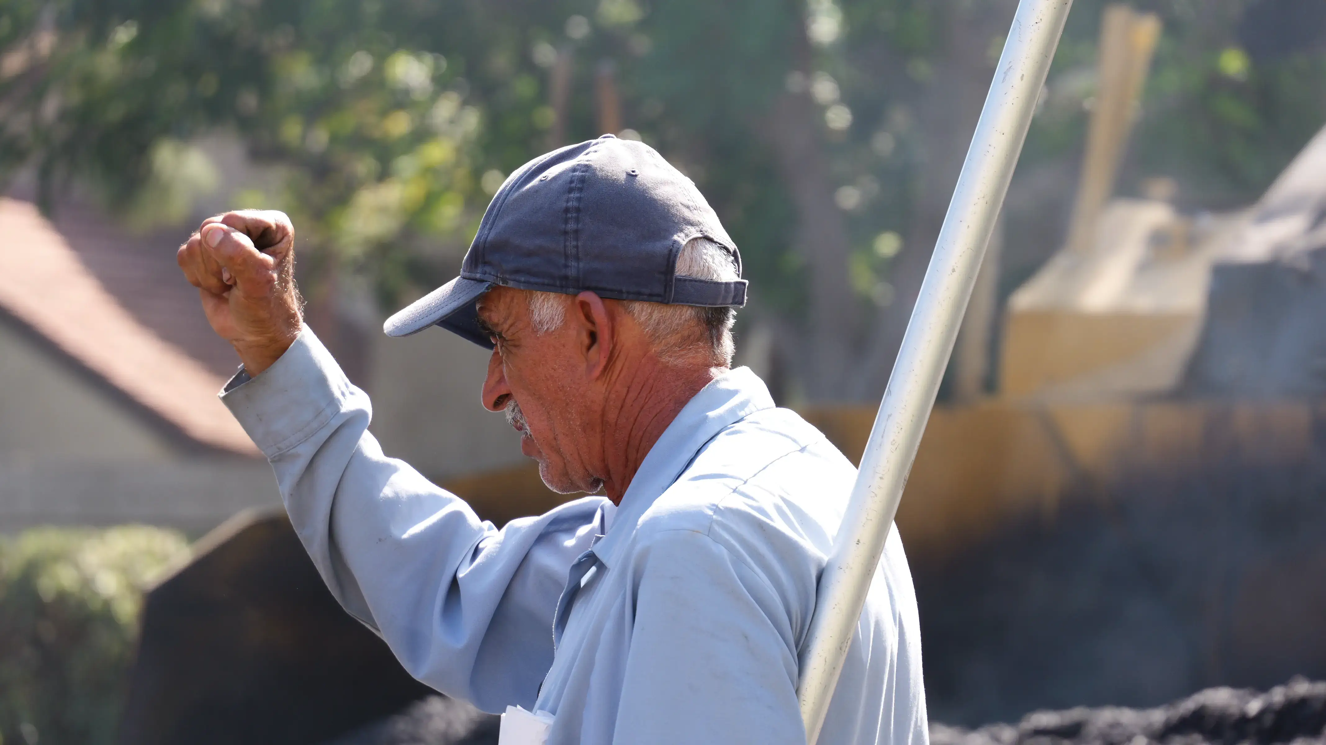 Asphalt crew member hand-signaling equipment operator