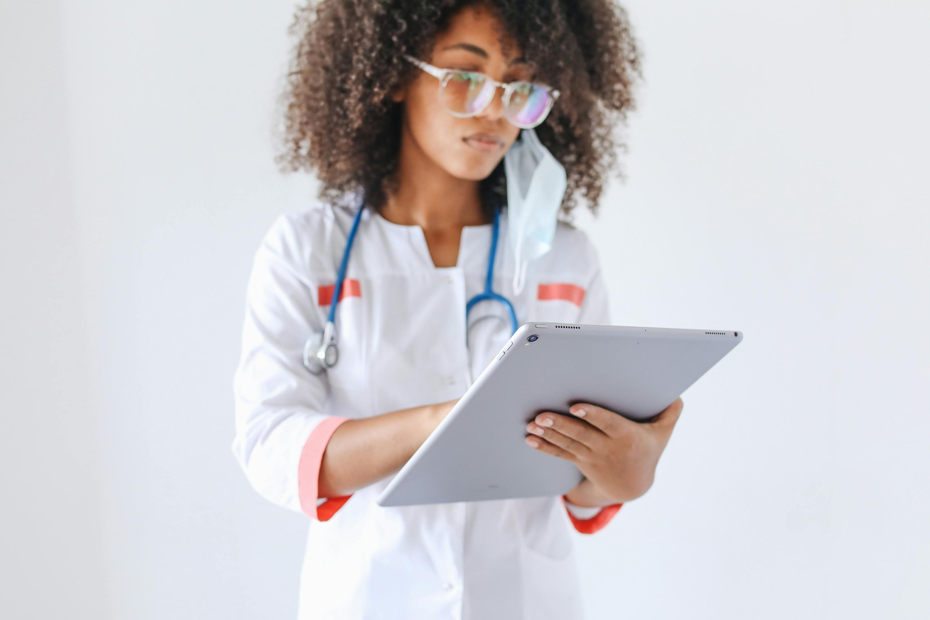 A doctor uses a tablet to respond to a patient’s concern.