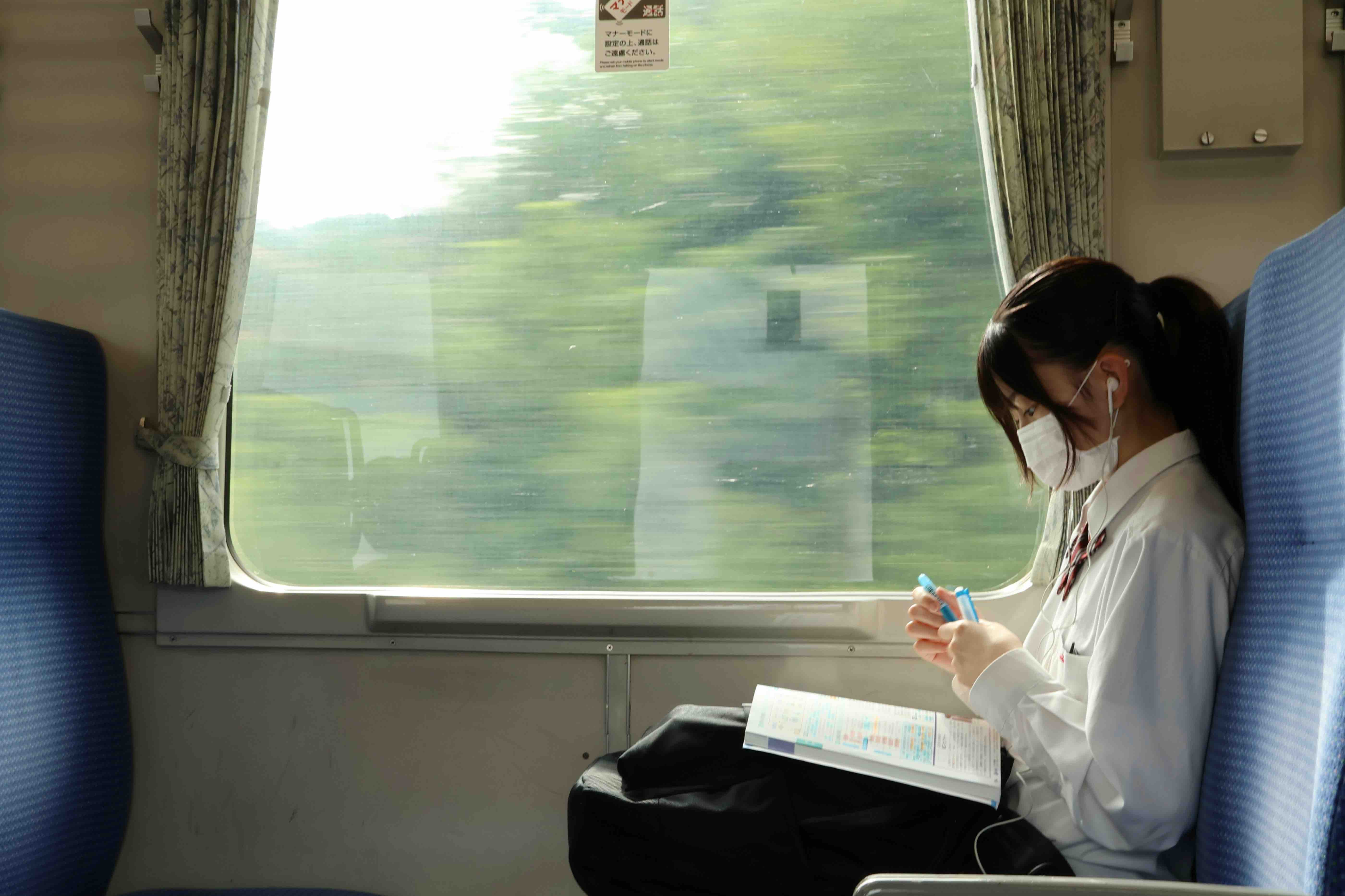 Girl sitting on train studying