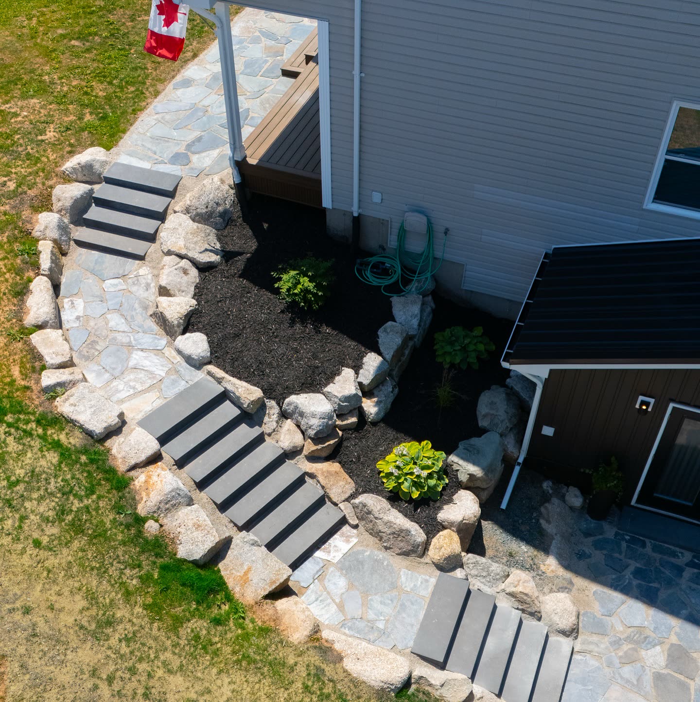 Edged and mulched garden beds along a stone walkway