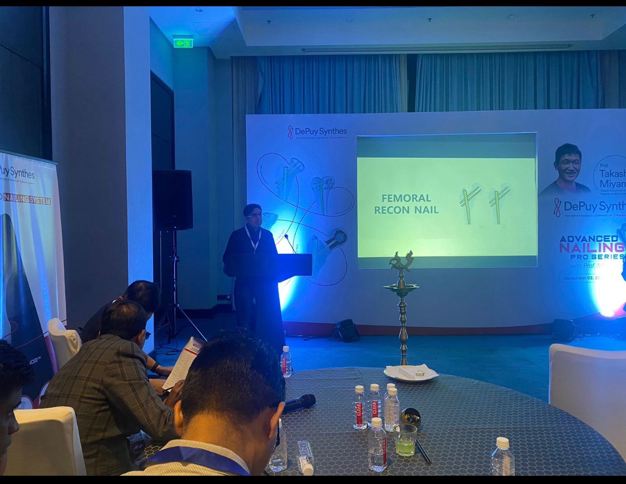 An astronaut riding a white horse on a hill overlooking a glowing pink and orange sky