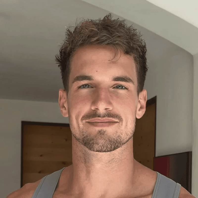 a man with a goatee smiles at the camera