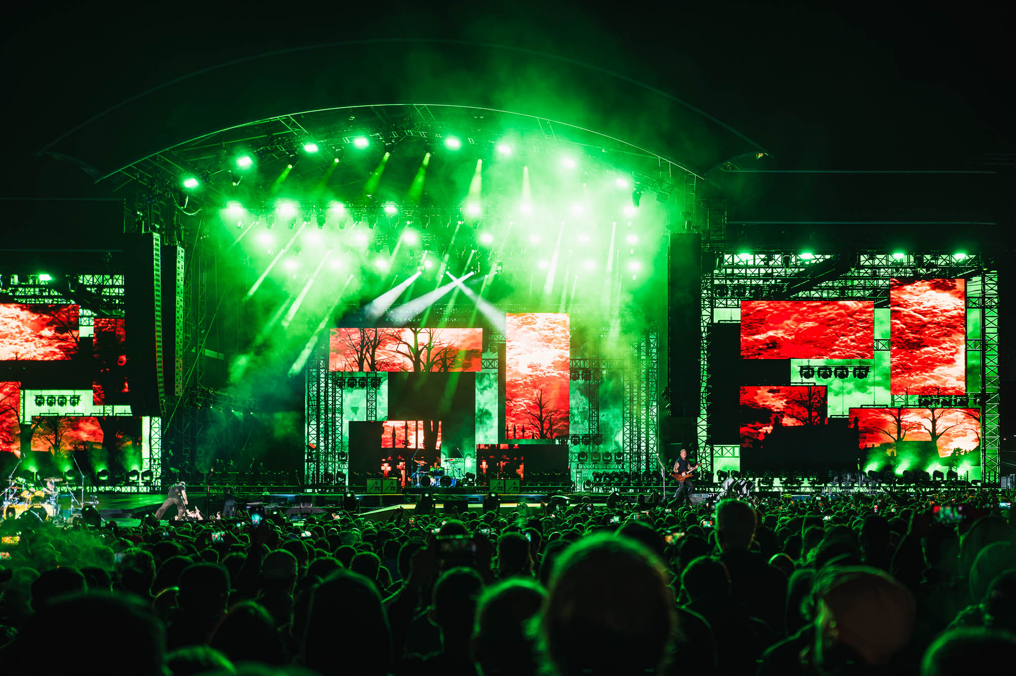 Scène Mainstage éclairée de vert, écrans latéraux rouges, concert de nuit au Hellfest