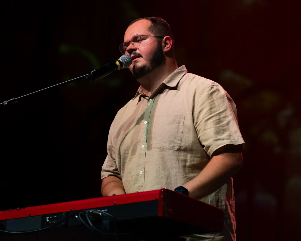 Worship Leader Carson singing and playing piano
