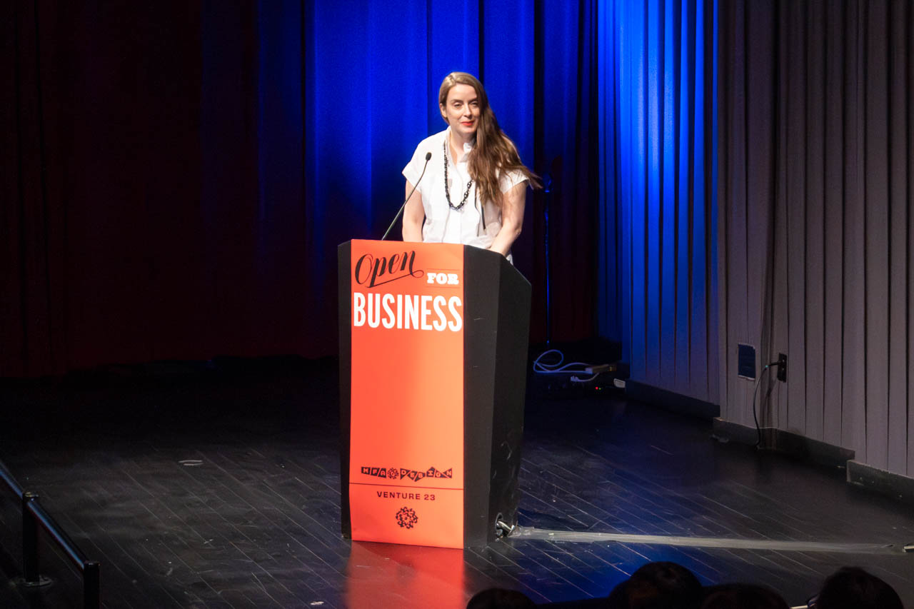 woman standing at a podium delivering a presentation