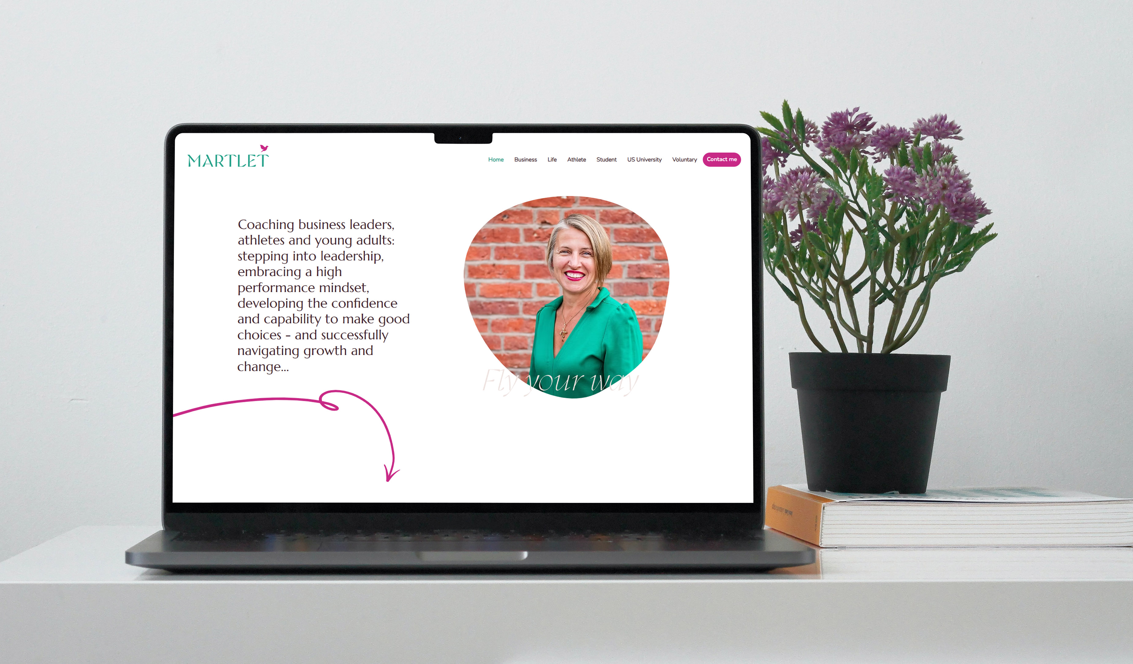 Martlet logo and website design in laptop on desk with pink plant