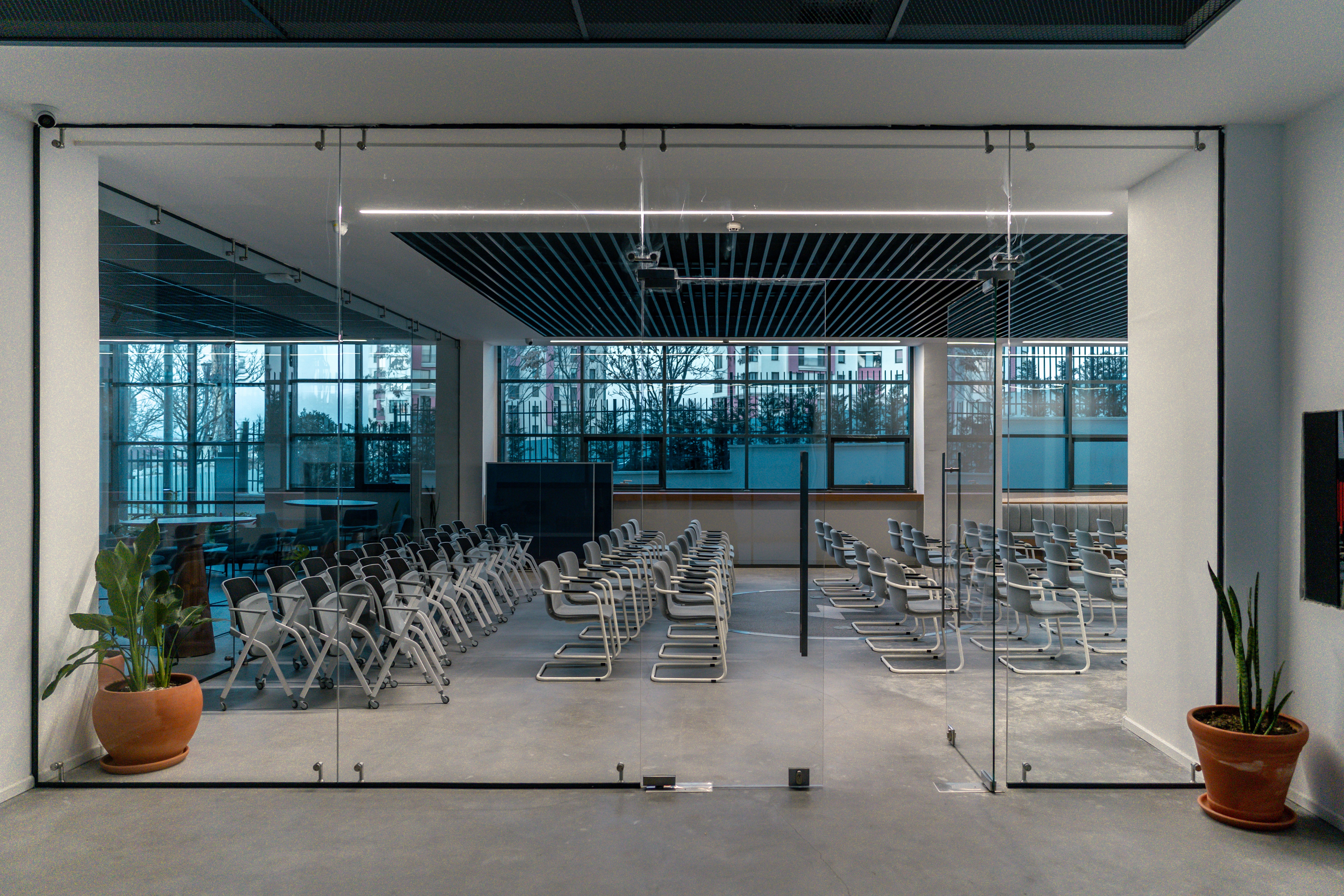 Modern conference room interior with glass partitions, minimalist seating layout, and acoustic ceiling panels — Ikas Office interior design in Ankara.
