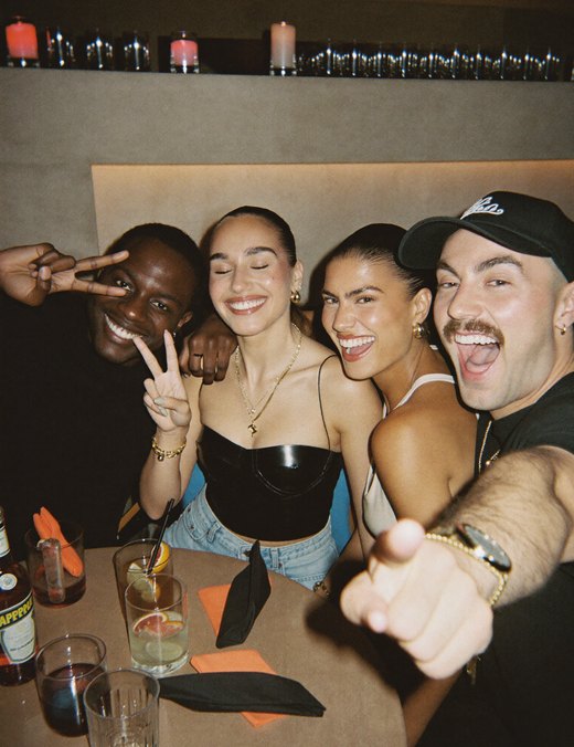 Four friends laughing around a table