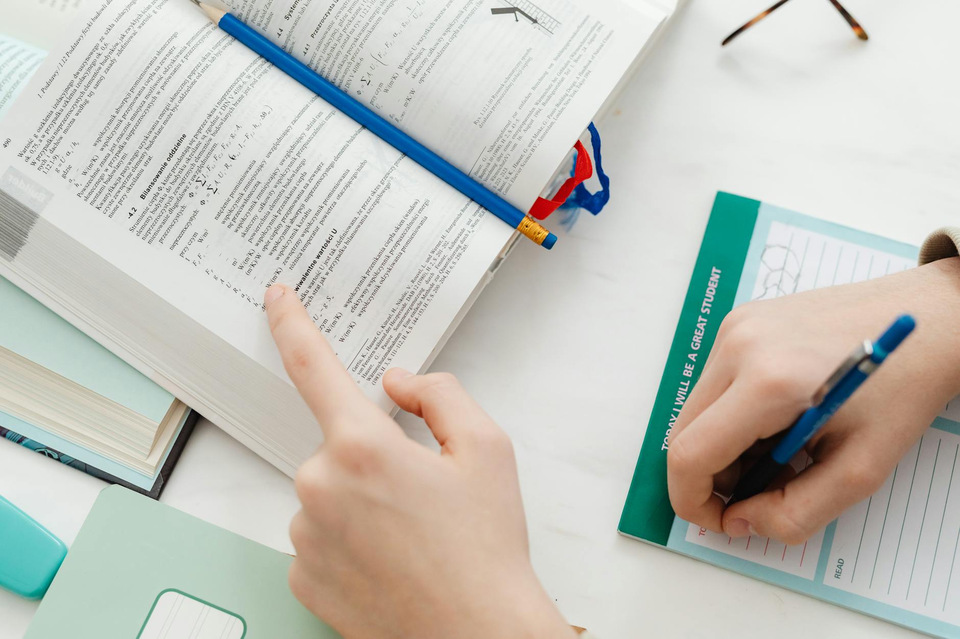 A messy but creative desk featuring open notebooks, clay sculptures, and various tactile learning materials.