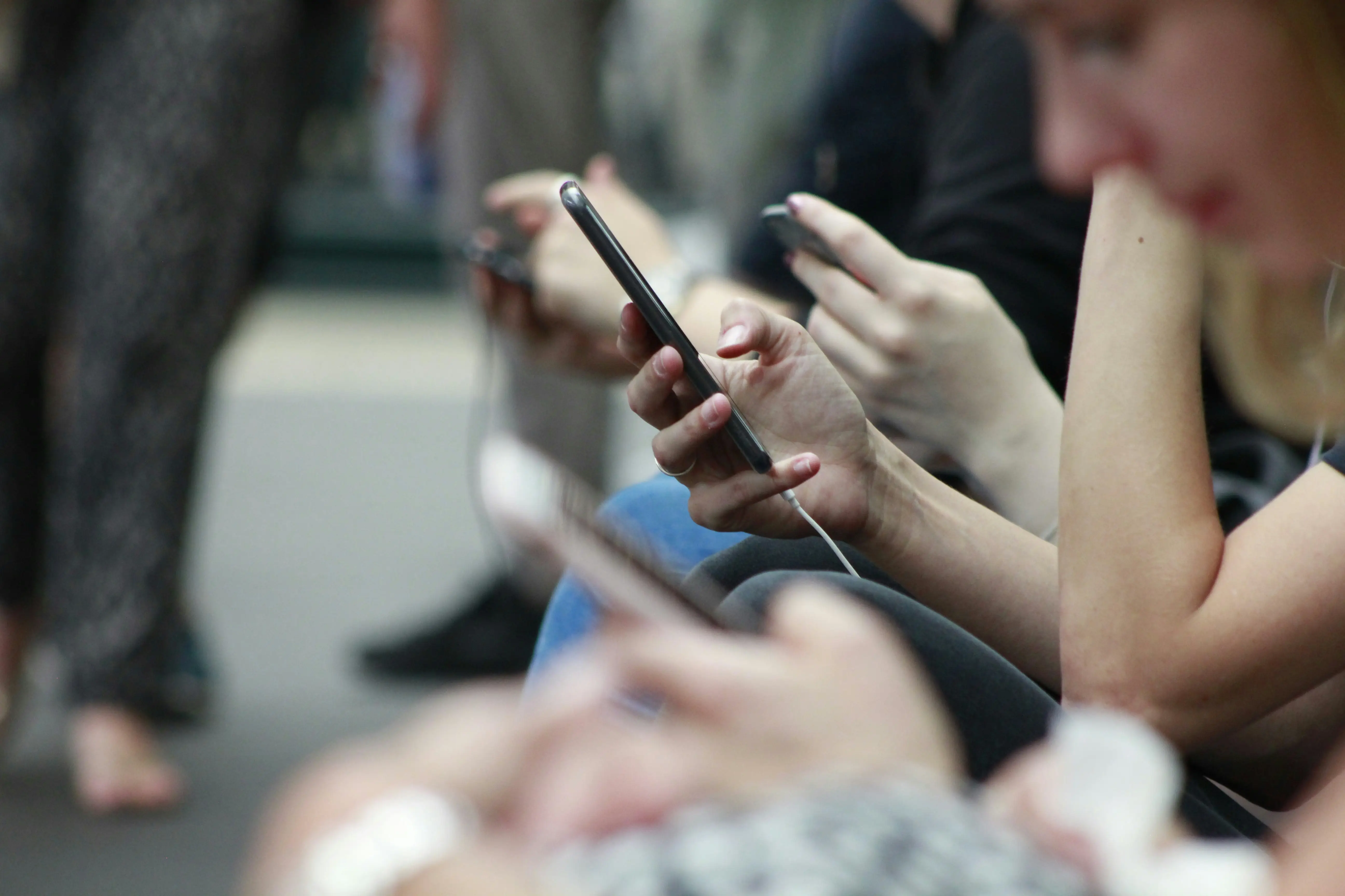 People using smartphones, illustrating the ease of accessing the latest updates and tips on product visualization.