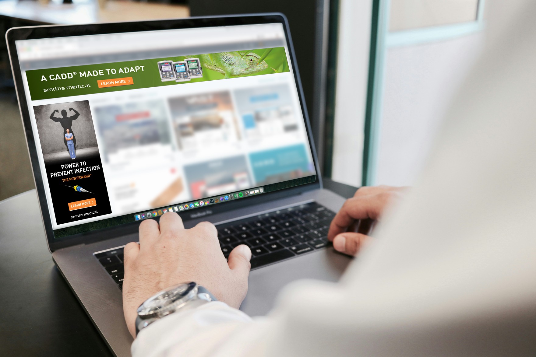 A person using a laptop which displays adverts for medical device products at various sizes.