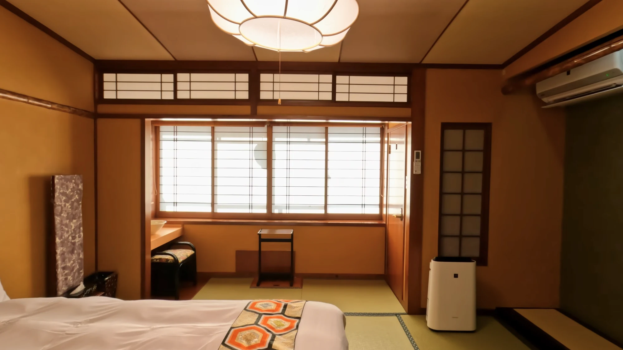 A simple tatami room in a Kinosaki inn with a futon laid out and a heater by the wall.