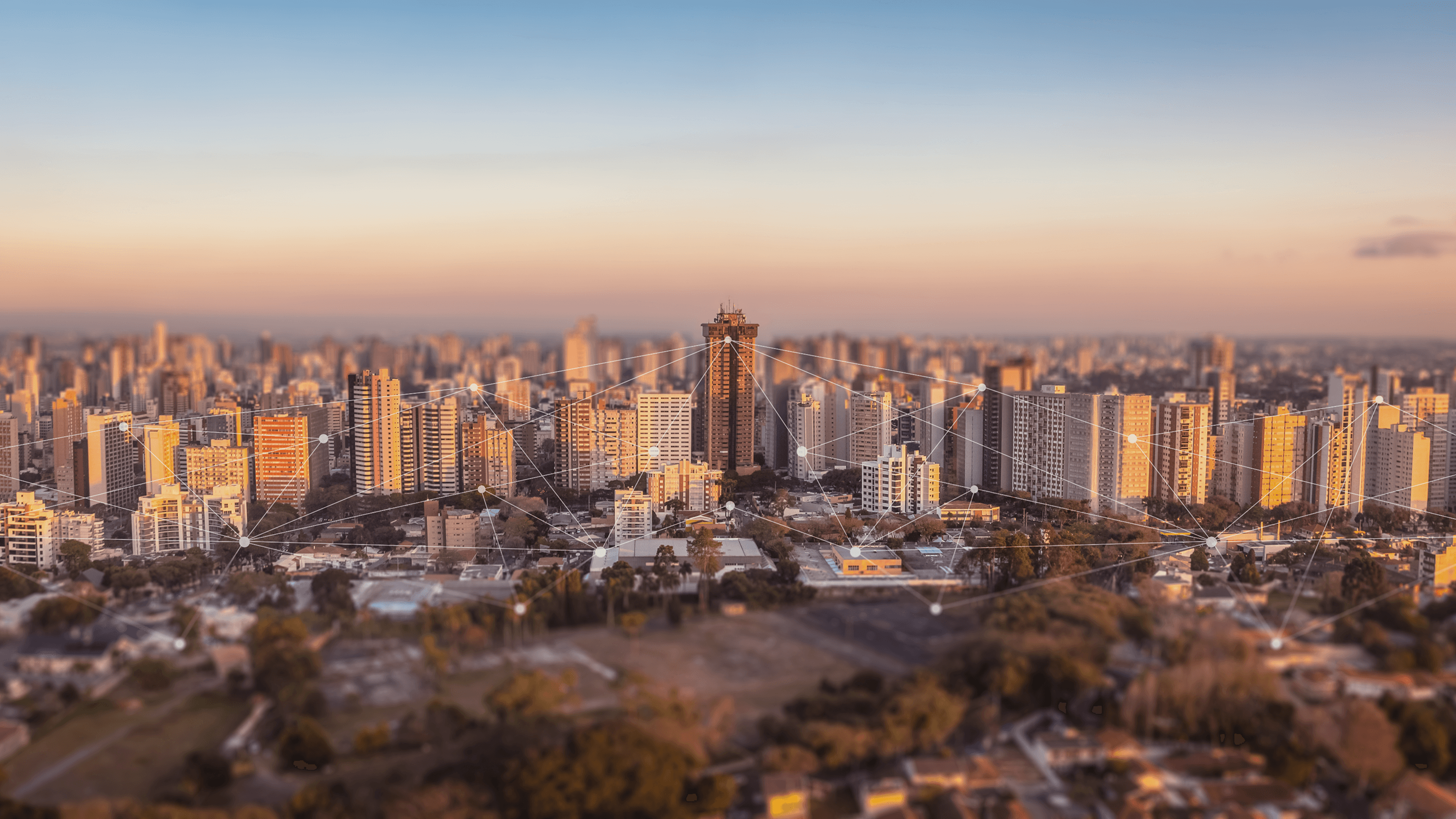 Panoramic view of Curitiba’s skyline at sunset, with a network of digital connections over the city.