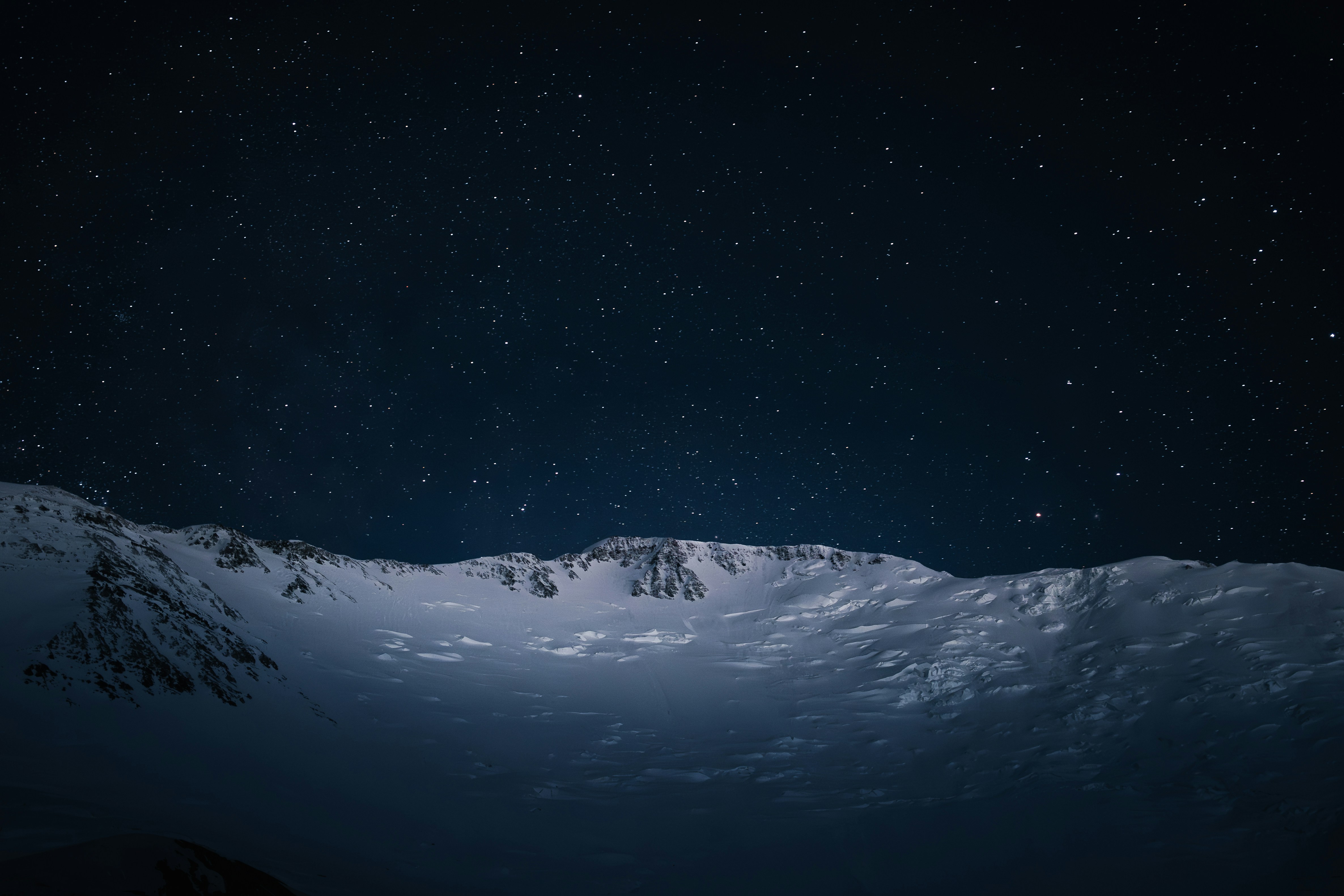 Snowy lunar landscape under a starry night sky