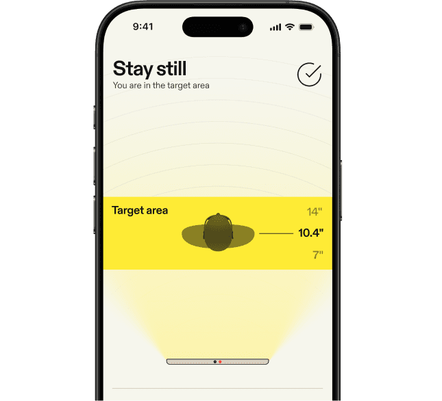 Mobile app screen instructing the user to stay still, showing a highlighted target area with distance measurements to ensure proper positioning.