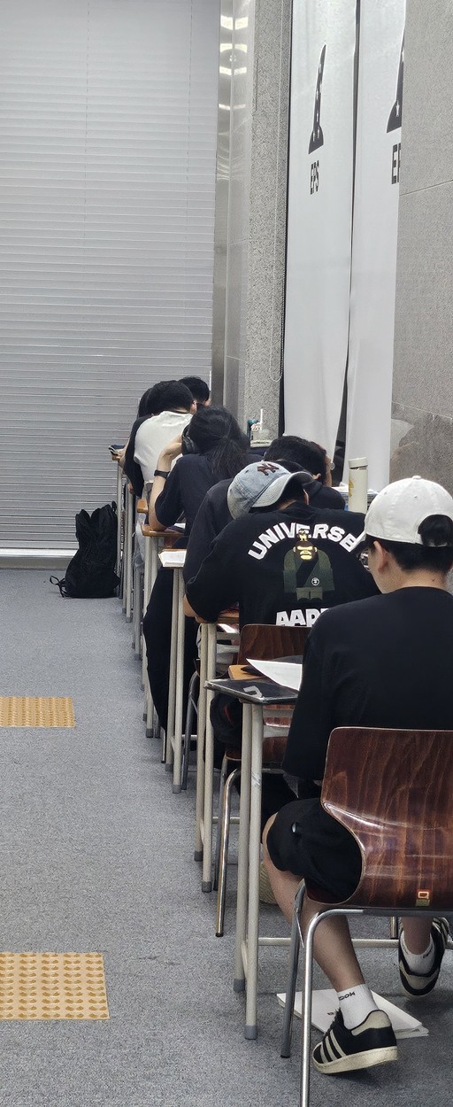 Cozy cafe corner with a round terrazzo table surrounded by wooden chairs, decorated with potted plants and a large mirror reflecting warm light.