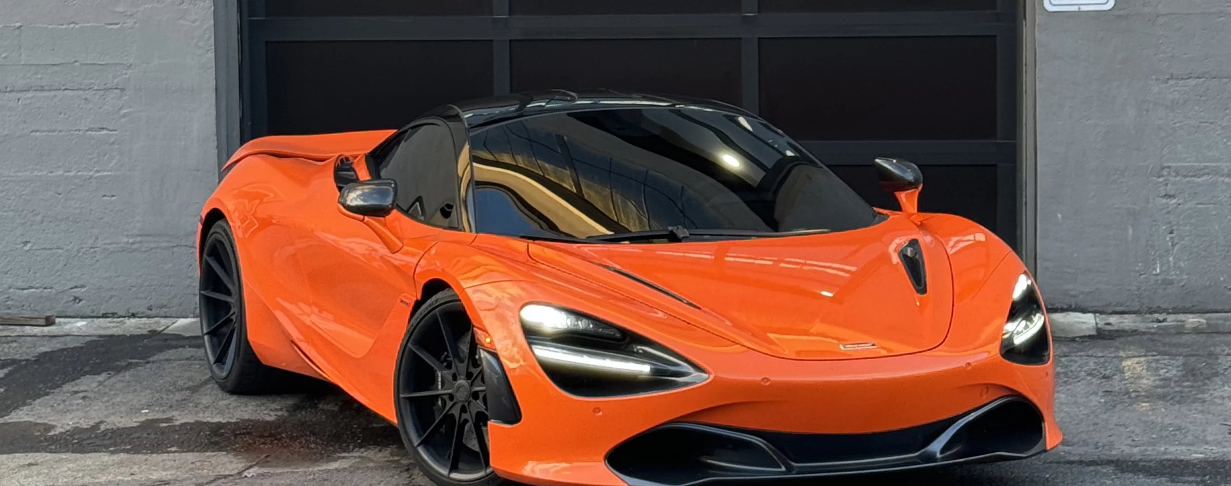 Orange McLaren 720S outside the 714 Technik roll-up door on N Tillamook St, Portland