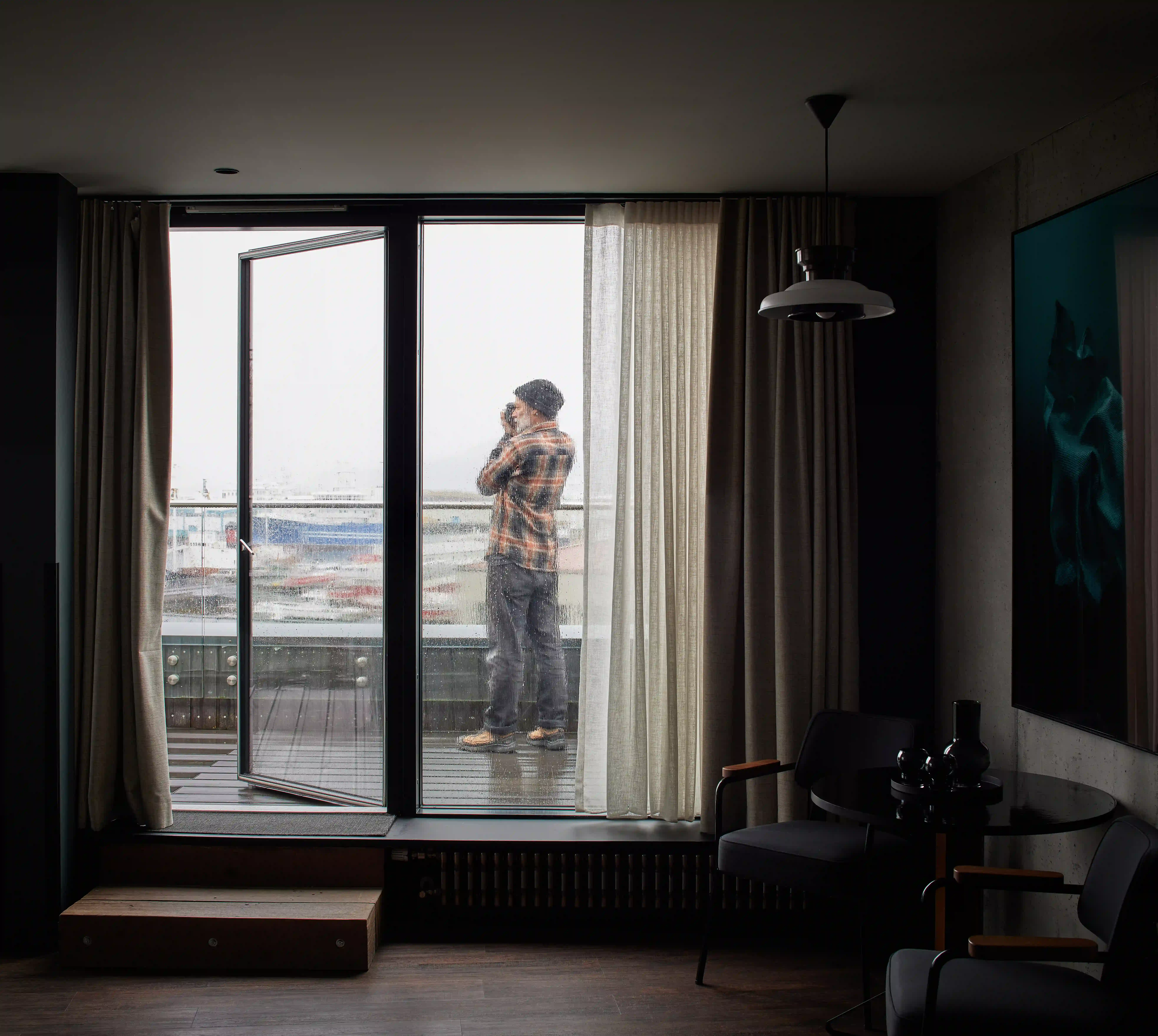 Guest photographing the harbour from inside the Harbour Suite.