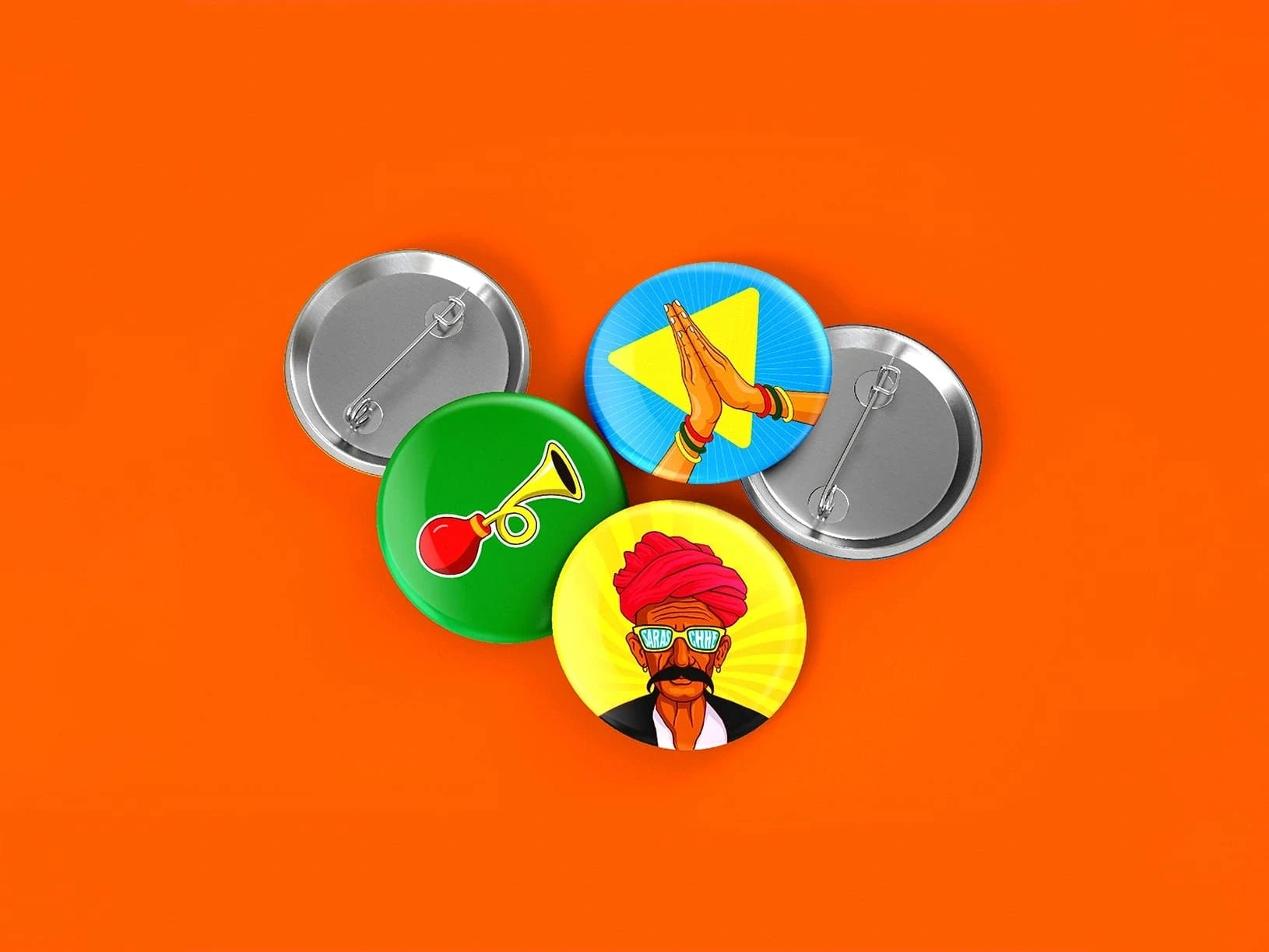 Five pin-back buttons on a bright orange background: a trumpet, praying hands, Sikh man in a red turban, and two gray button backs.