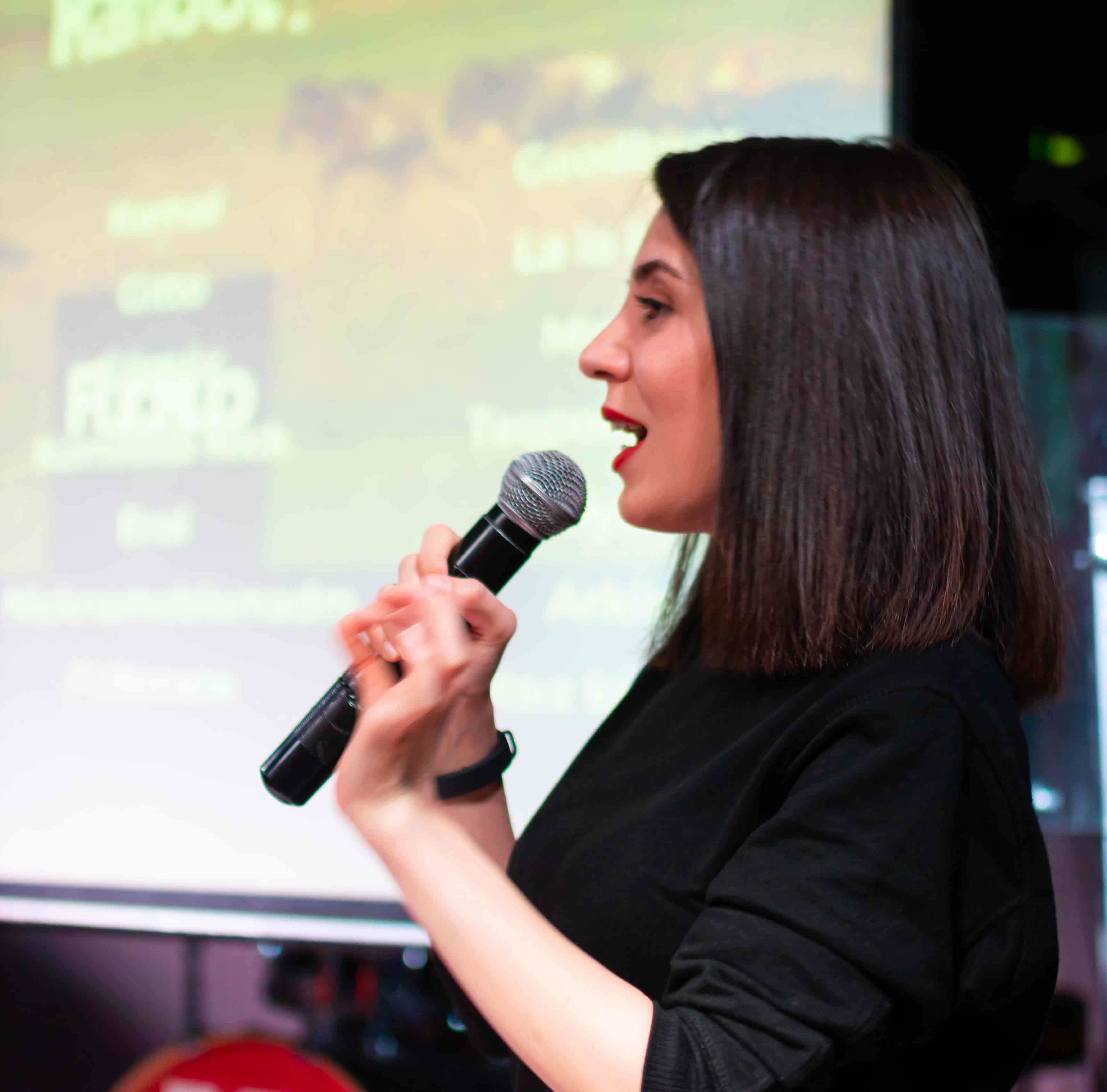 Öykü’nün yüzünün yakın planda göründüğü, sahnede mikrofonla konuştuğu bir fotoğraf.