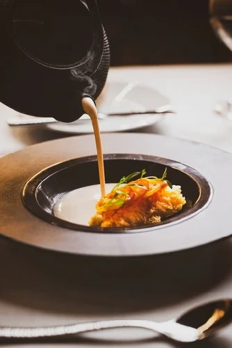 Elegant plated dish featuring meat with colorful sauce on white porcelain