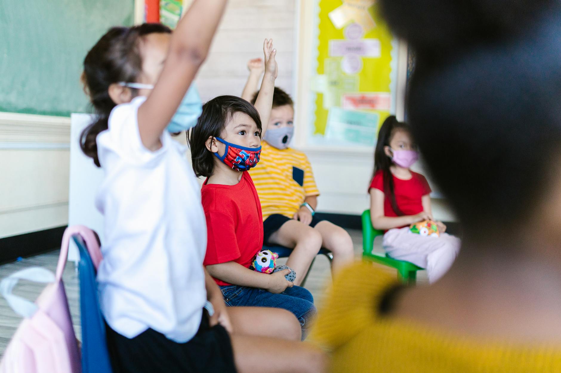 Elementary students sitting on a rug listening to a story compared to high schoolers working in a science lab.