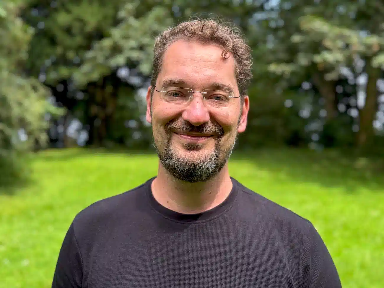 Portrait of Carlo Matic, Shareholder and Advisor at CoachingArea, standing outdoors in a green setting. Carlo supports CoachingArea with expertise in UX, innovation and early-stage strategies. He is a multiple-time founder, angel investor with several successful exits, and CEO of the digital solutions agency Interactive Pioneers.