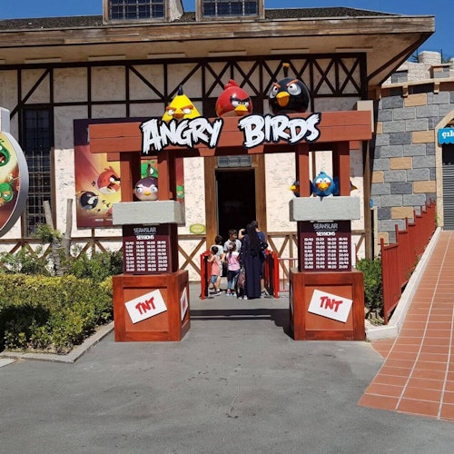 Pagpasok sa isang atraksyon na may tema ng Angry Birds, kung saan makikita ang makukulay na estatwa ng mga karakter at mga tao na pumapasok.