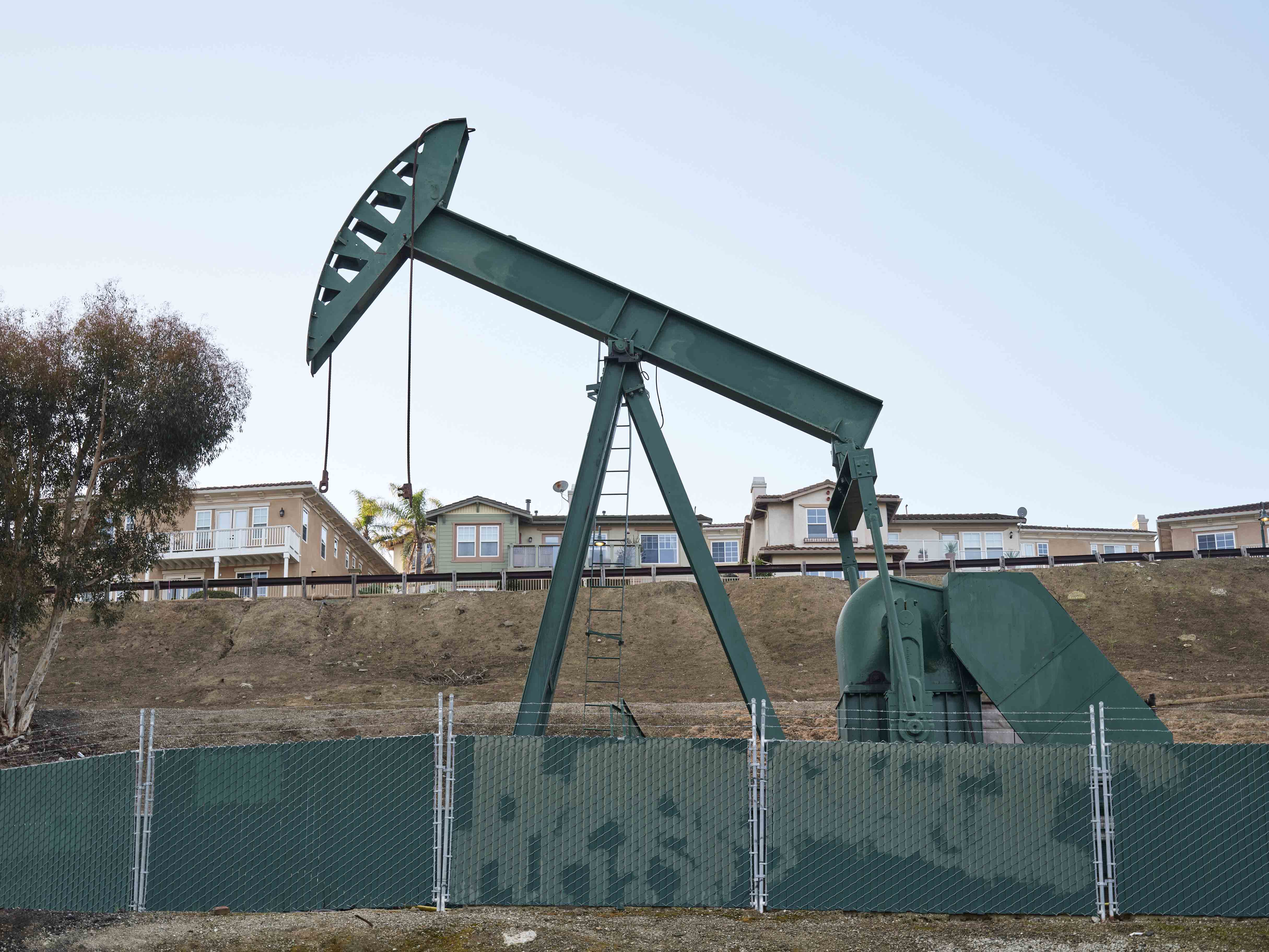 An oil rig in front of houses in a California neighborhood.