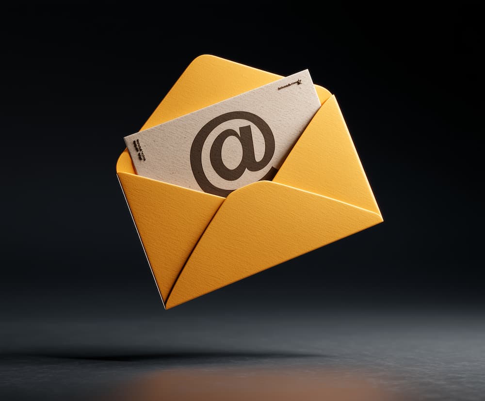 Two men discuss a project while standing at a laptop in an office.