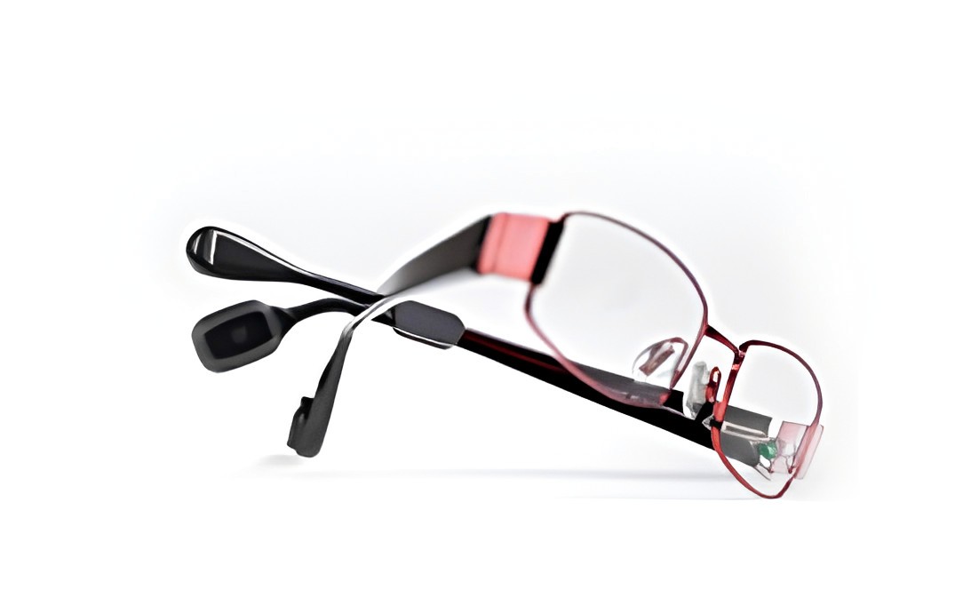 Spectacle hearing aid built into the arm of a pair of glasses